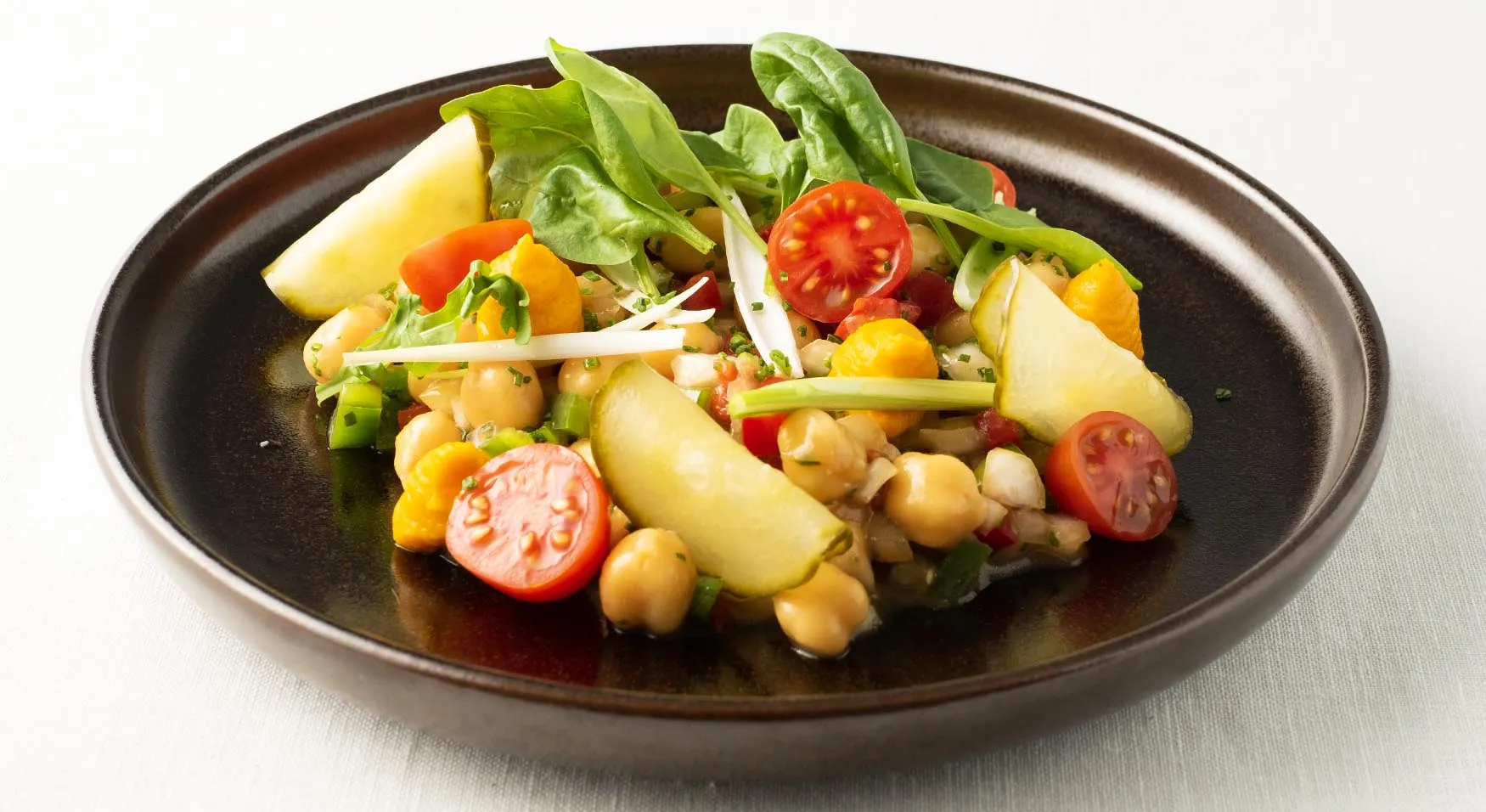 Ensalada de garbanzo con hojas frescas, encurtidos y verduras