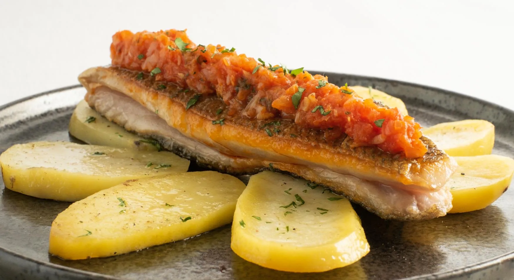 Lubina fresca a la donostiarra sobre láminas de patata confitadas